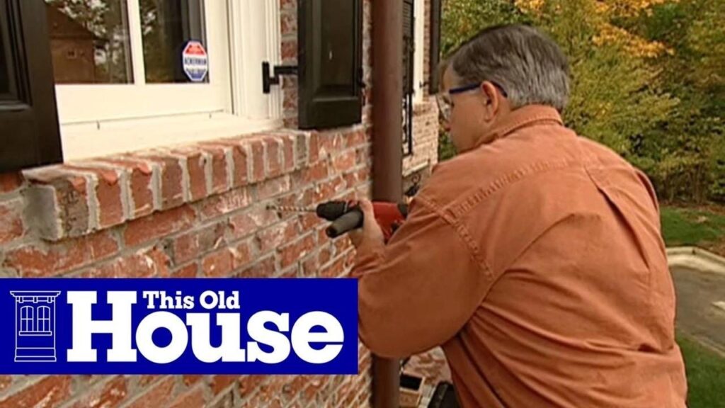 image Person using a drill on a brick wall outside a house, featured on This Old House show. | Sky Rye Design Person using a drill on a brick wall outside a house, featured on This Old House show.