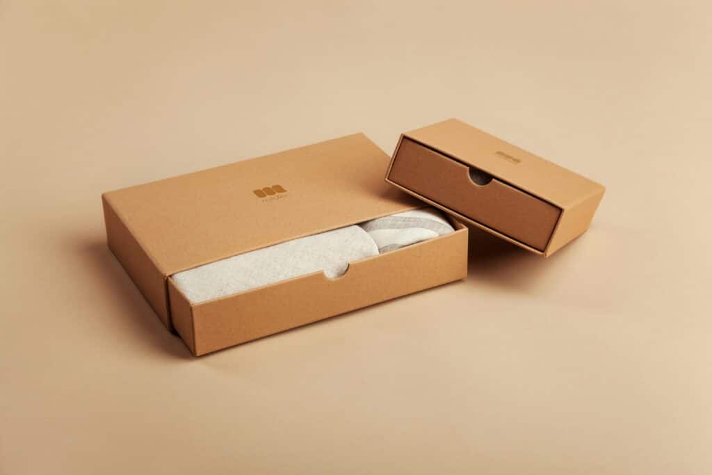 Minimalist packaging featuring two elegant brown cardboard boxes on a beige background for eco-friendly product presentation.