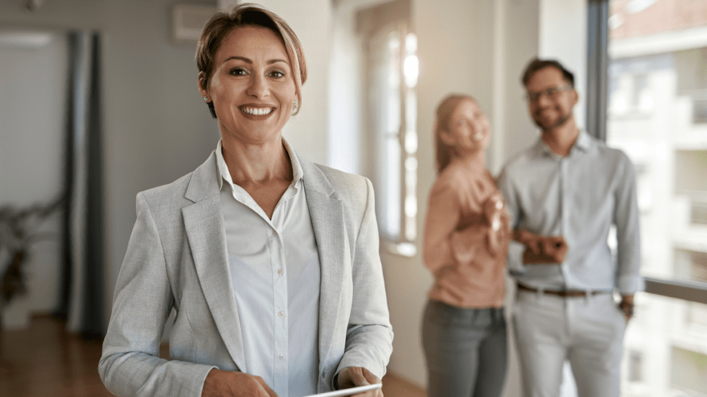 Smiling businesswoman with tablet in office, confident colleagues in background. Professional team environment.