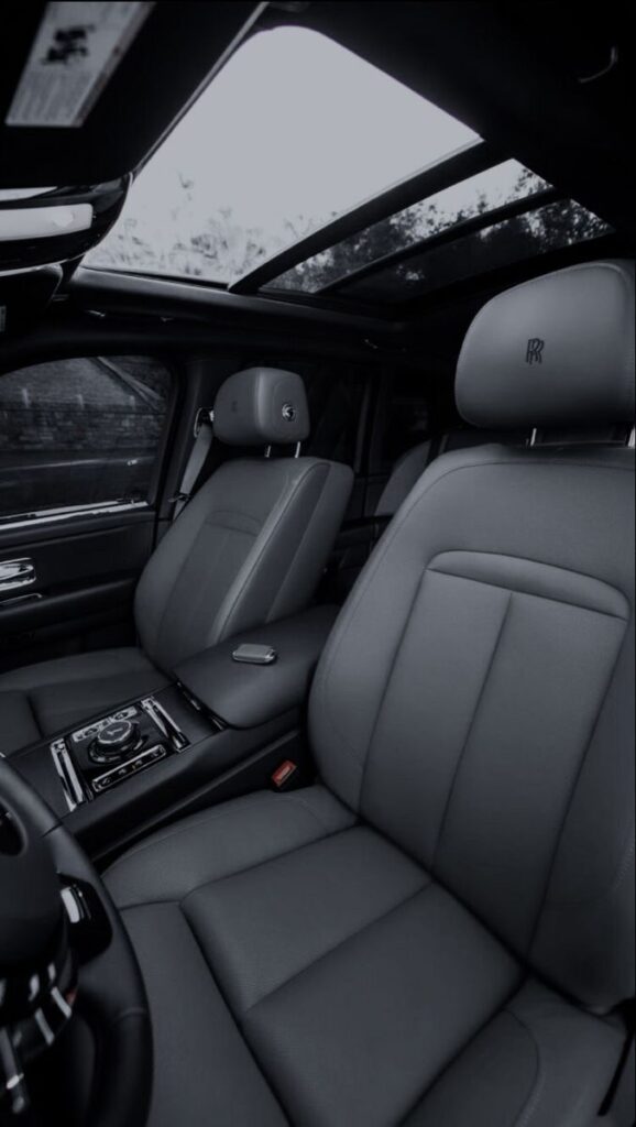 Luxury car interior with plush grey leather seats and panoramic sunroof, showcasing sleek design and comfort.