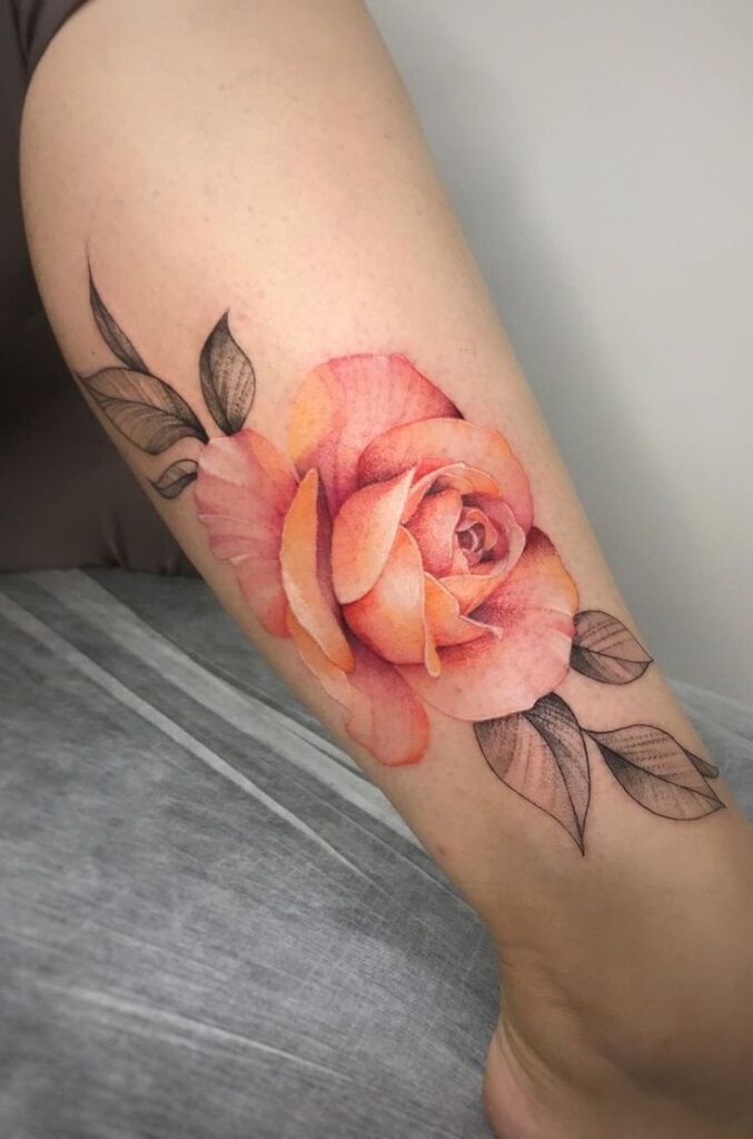 Realistic peach rose tattoo with leaves on forearm, showcasing intricate shading and vibrant petals.