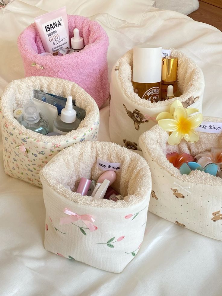 zdnd Colorful skincare products in decorative fabric baskets on a bed, featuring floral and teddy bear patterns. | Sky Rye Design Colorful skincare products in decorative fabric baskets on a bed, featuring floral and teddy bear patterns.