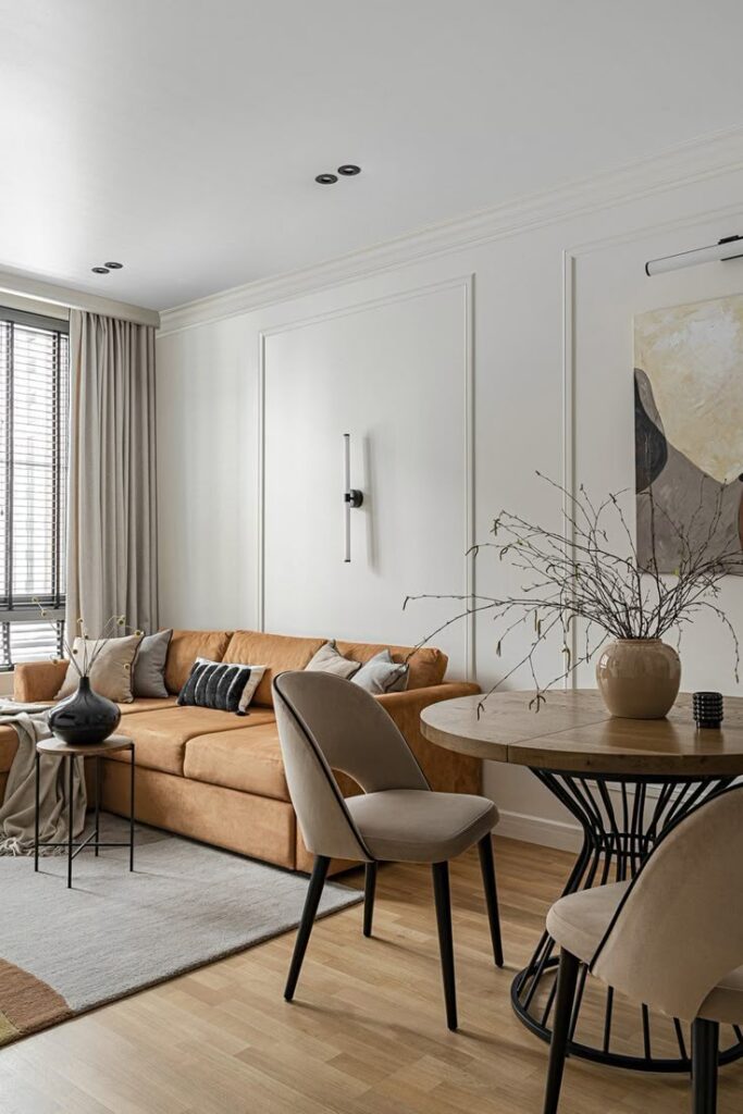 Modern living room with cozy beige sofa, stylish decor, round table, and neutral tones, creating a warm and inviting atmosphere.