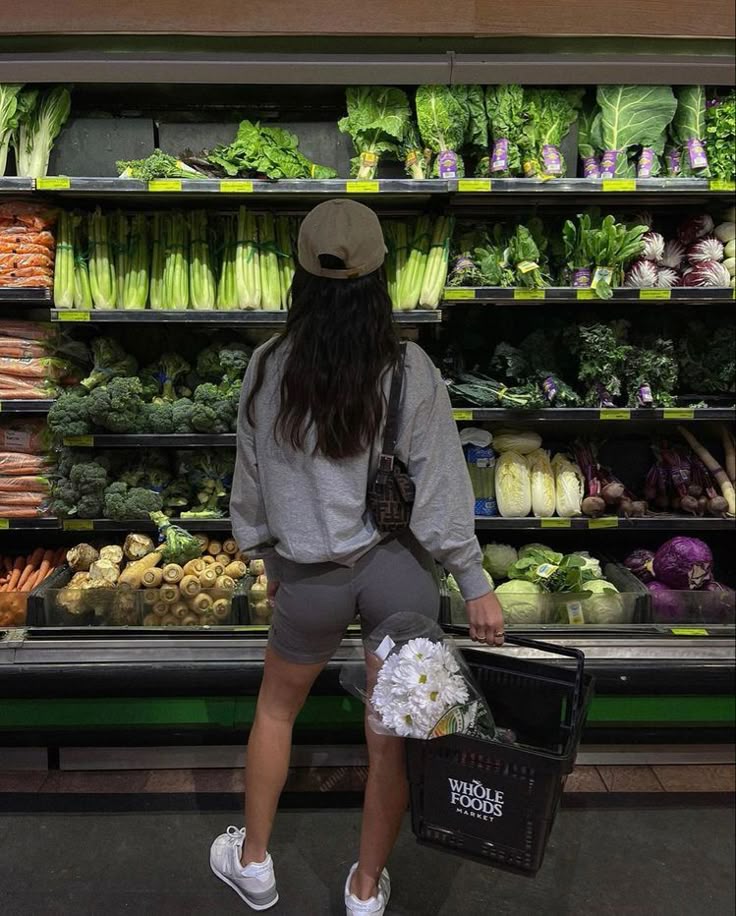 🍒 Woman shopping for fresh vegetables at Whole Foods, holding a basket with flowers. | Sky Rye Design Woman shopping for fresh vegetables at Whole Foods, holding a basket with flowers.