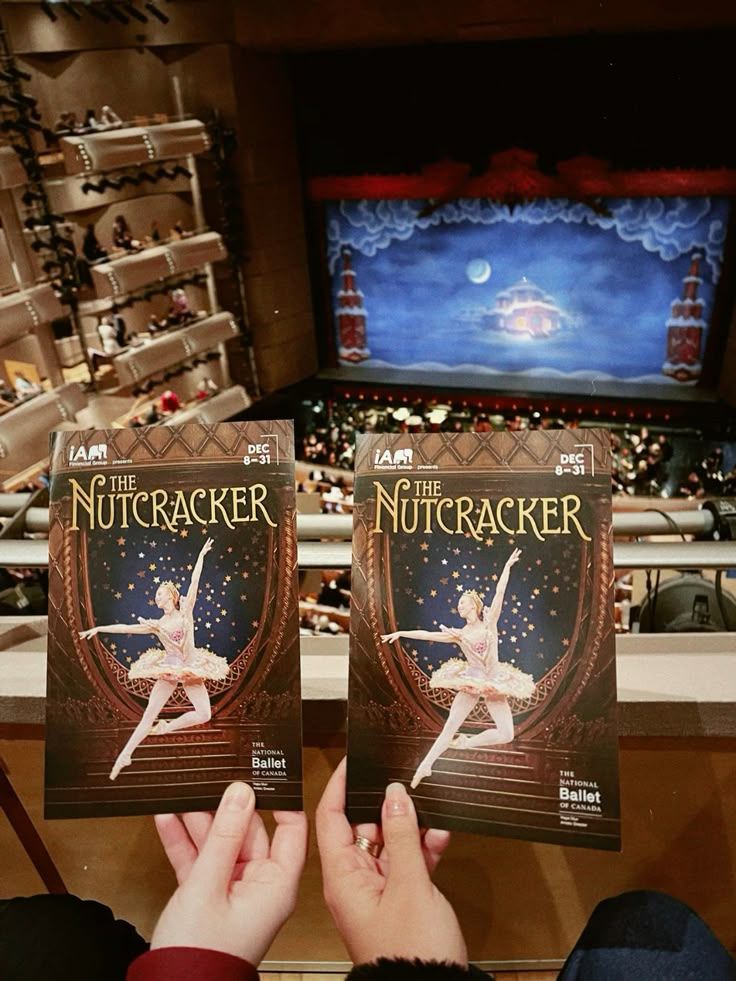 View of a theater interior with audience. Two people hold The Nutcracker programs by The National Ballet of Canada, December 8–31.