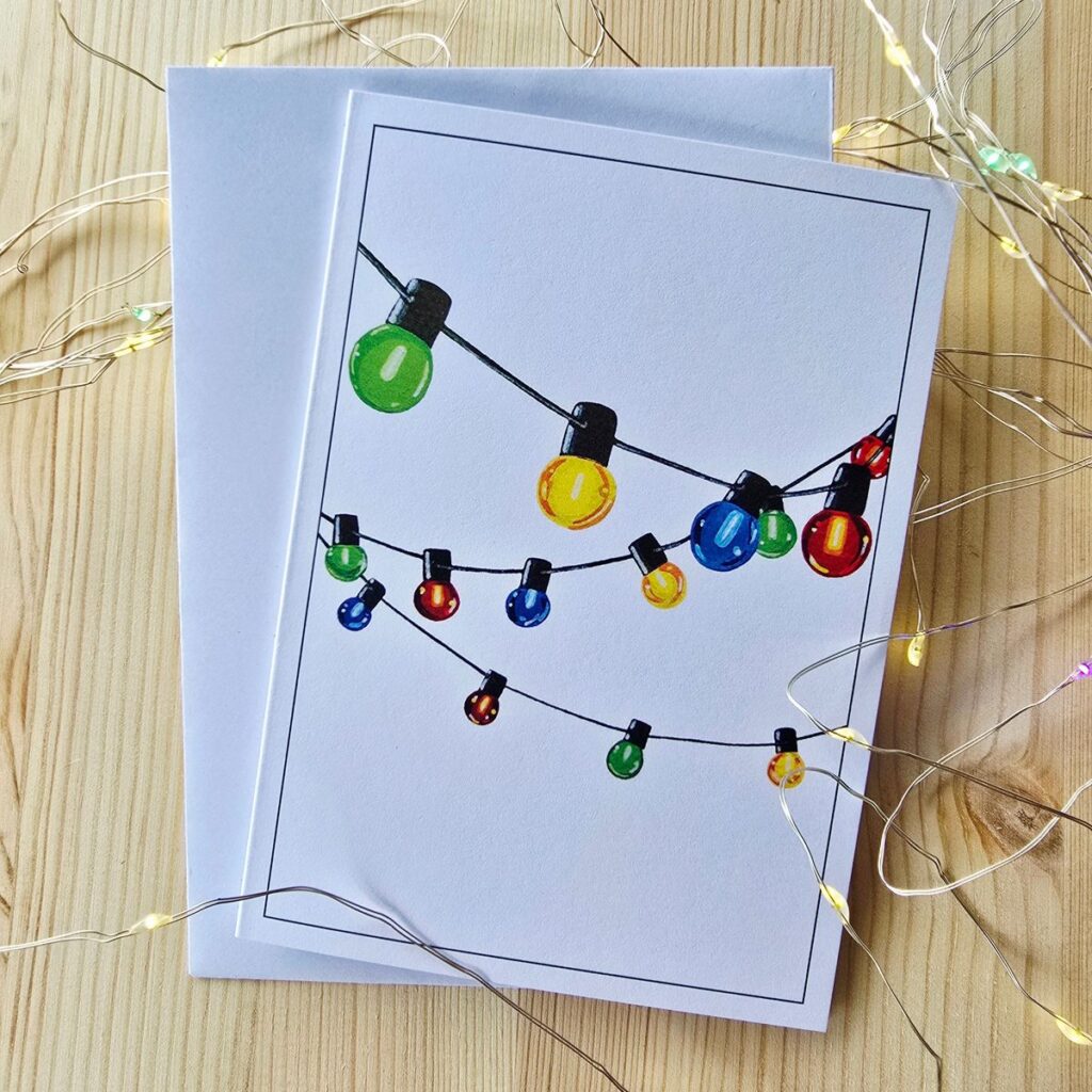 0204ecded00cdc8e95a1db8e6912a0be Greeting card with colorful string lights design on a wooden surface, surrounded by LED fairy lights. Perfect for festive occasions. | Sky Rye Design Greeting card with colorful string lights design on a wooden surface, surrounded by LED fairy lights. Perfect for festive occasions.