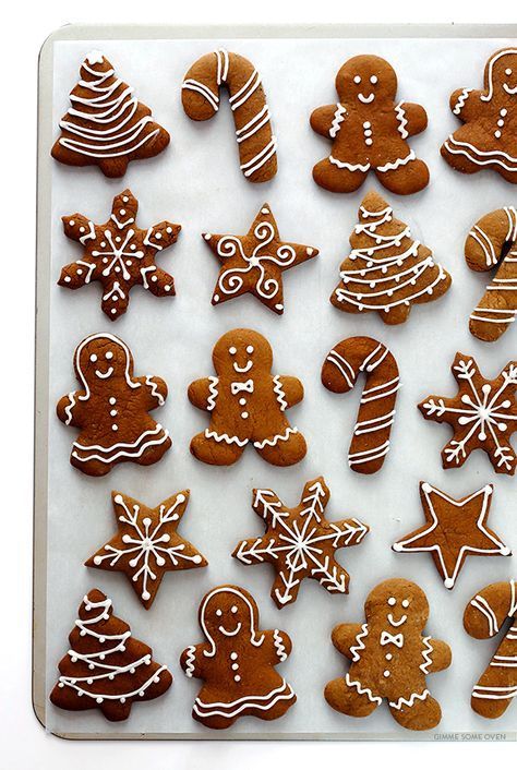 027b162243e83b7868d95855614de98d Assorted gingerbread cookies in festive shapes like trees, stars, and snowflakes with icing, arranged on a white baking tray. | Sky Rye Design Assorted gingerbread cookies in festive shapes like trees, stars, and snowflakes with icing, arranged on a white baking tray.