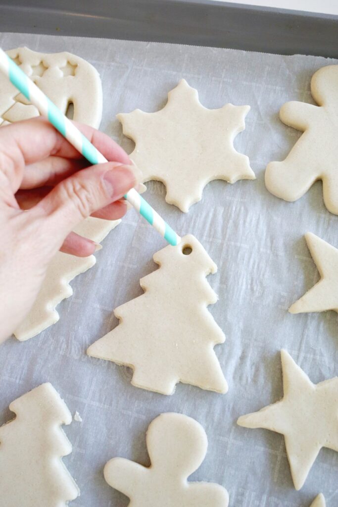 084f630d57d6e18ae26f85008db5f905 Hand poking holes in holiday salt dough ornaments, including tree and snowflake shapes, on a baking sheet. Perfect for crafts. | Sky Rye Design Hand poking holes in holiday salt dough ornaments, including tree and snowflake shapes, on a baking sheet. Perfect for crafts.