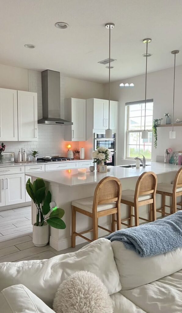 0b7a19f6-8ed1-4471-ba9c-ece97a103c68 Modern kitchen with white cabinets, an island with wooden chairs, and pendant lighting, creating a cozy and elegant cooking space. | Sky Rye Design Modern kitchen with white cabinets, an island with wooden chairs, and pendant lighting, creating a cozy and elegant cooking space.