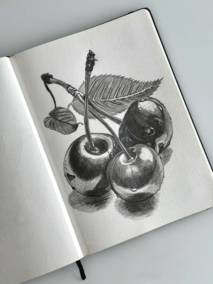 Pencil sketch of three cherries with leaves on a notebook, showcasing detailed shading and textures. Perfect for art enthusiasts and sketch lovers.