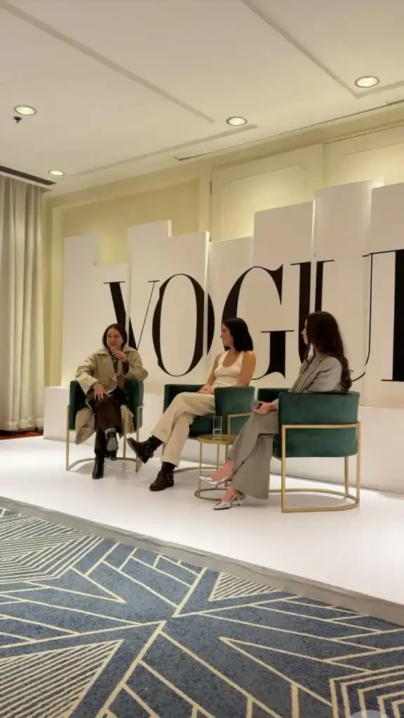 Screenshot Panel discussion at Vogue event with three people seated on stage, engaged in conversation. | Sky Rye Design Panel discussion at Vogue event with three people seated on stage, engaged in conversation.