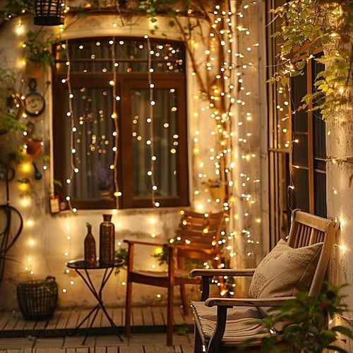 1 pack 50 LED Fairy Lights - 5 Meter 3AA Battery Powered Perfect for Christmas Weddings Parties Family Vacations Gatherings and More - Always On Cozy outdoor patio with a wooden bench, twinkling string lights, and a small table, creating a warm and inviting evening ambiance. | Sky Rye Design Cozy outdoor patio with a wooden bench, twinkling string lights, and a small table, creating a warm and inviting evening ambiance.