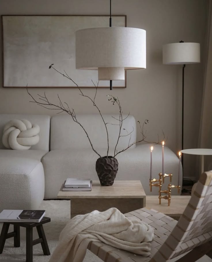 Modern minimalist living room with neutral tones, featuring a cozy sofa, abstract art, and elegant decor elements like a sculptural vase.