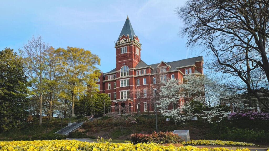 139755_hero Historic brick building surrounded by spring trees and flowers at a university campus under clear blue sky. | Sky Rye Design Historic brick building surrounded by spring trees and flowers at a university campus under clear blue sky.