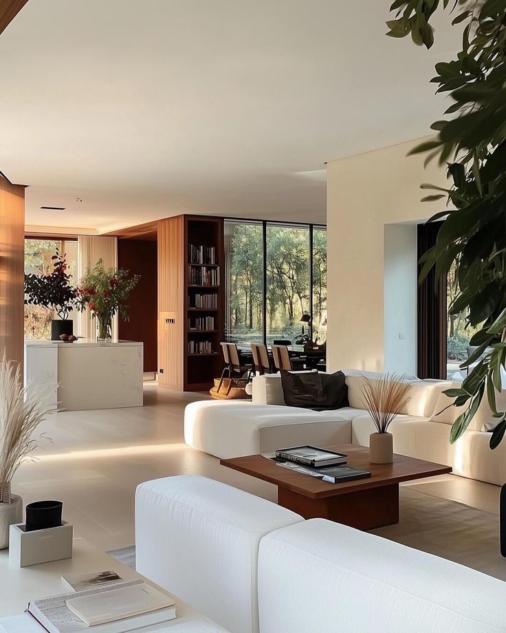 _ 17 Modern, spacious living room with white sofas, wooden accents, large windows, and elegant decor, overlooking a scenic outdoor view. | Sky Rye Design Modern, spacious living room with white sofas, wooden accents, large windows, and elegant decor, overlooking a scenic outdoor view.