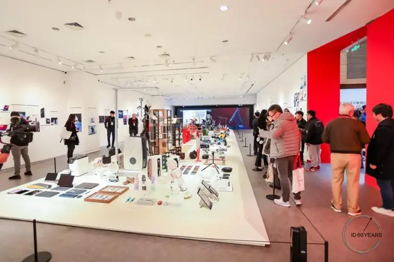 1A7DC012714455A381BEF86E635_4312D98A_12C22 People explore a modern exhibition showcasing various gadgets and tech innovations, highlighted by bright lighting and informative displays. | Sky Rye Design People explore a modern exhibition showcasing various gadgets and tech innovations, highlighted by bright lighting and informative displays.