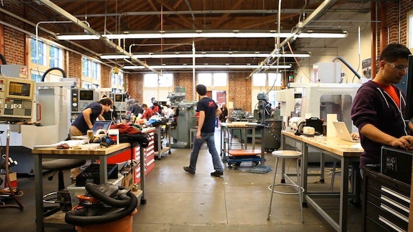 1_mWwNWgc1S-RdDAwcN1H-qA Spacious workshop with engineers working on machines, tables filled with tools, and bright lighting through large windows. | Sky Rye Design Spacious workshop with engineers working on machines, tables filled with tools, and bright lighting through large windows.