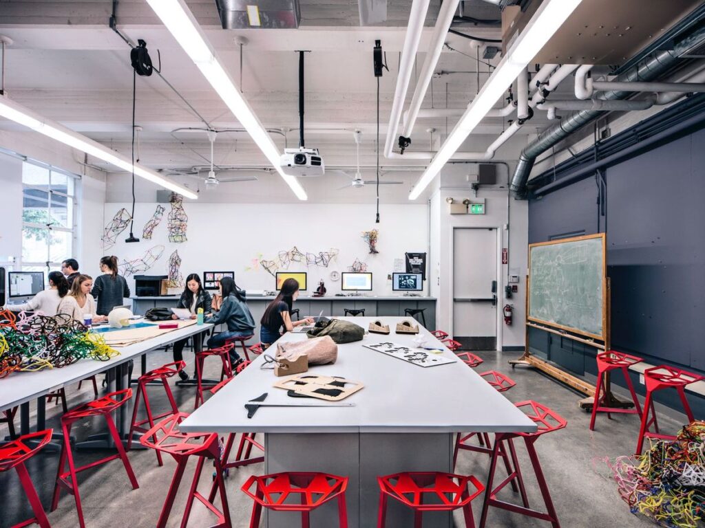1a11d858a6b33f1b19ae051c29c2d34f Creative workspace with people collaborating at a table. Modern design features red stools, artworks on walls, and a large green chalkboard. | Sky Rye Design Creative workspace with people collaborating at a table. Modern design features red stools, artworks on walls, and a large green chalkboard.