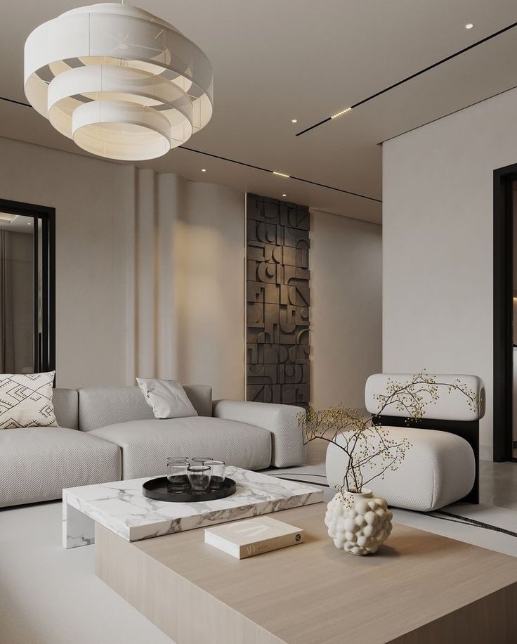Modern minimalist living room with white sofa, marble coffee table, contemporary chandelier, and abstract wall art.