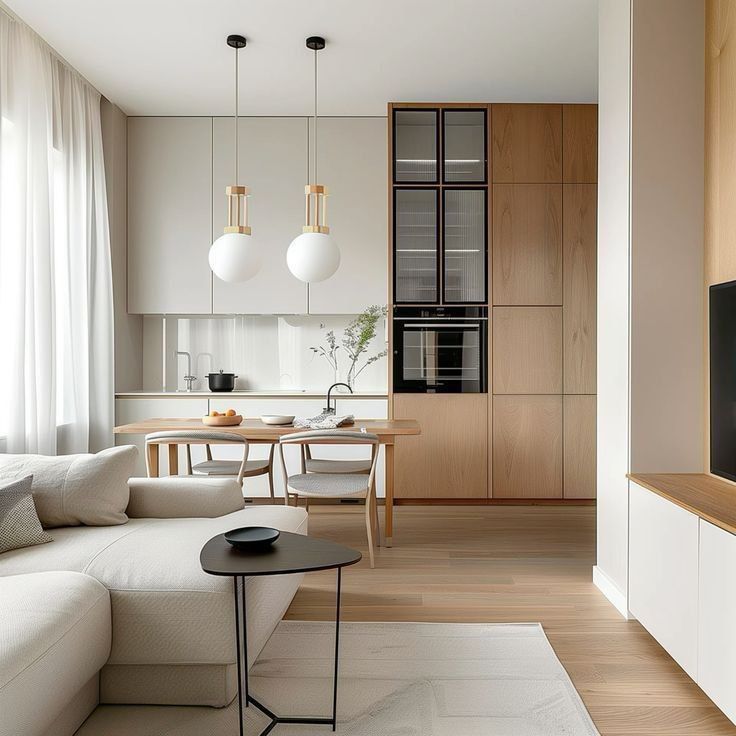 Modern living room with minimalist kitchen, pendant lights, beige sofa, wooden cabinetry, and dining table. Cozy and stylish interior design.