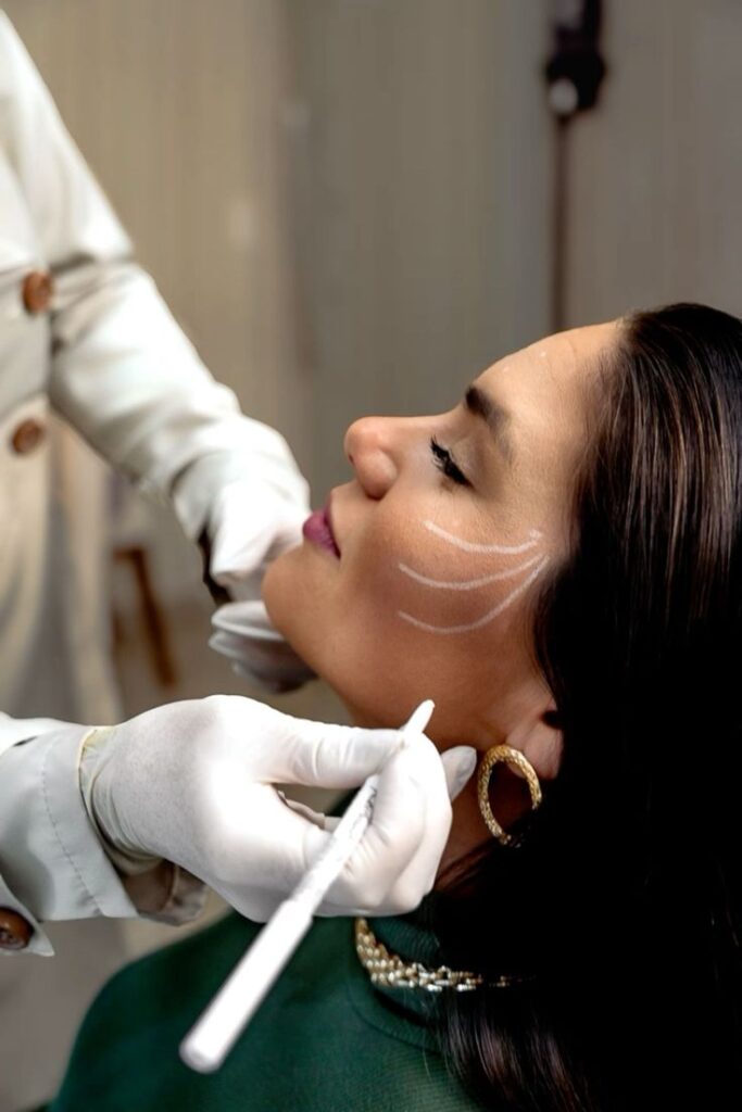 _ 2 Woman undergoing cosmetic procedure with skin markings. Doctor in white gloves preparing for aesthetic treatment. | Sky Rye Design Woman undergoing cosmetic procedure with skin markings. Doctor in white gloves preparing for aesthetic treatment.