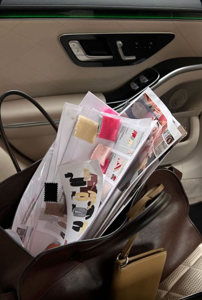 _ 2 Bag with fabric swatches and fashion sketches placed on a car seat, hinting at a designer's work in progress. | Sky Rye Design Bag with fabric swatches and fashion sketches placed on a car seat, hinting at a designer's work in progress.