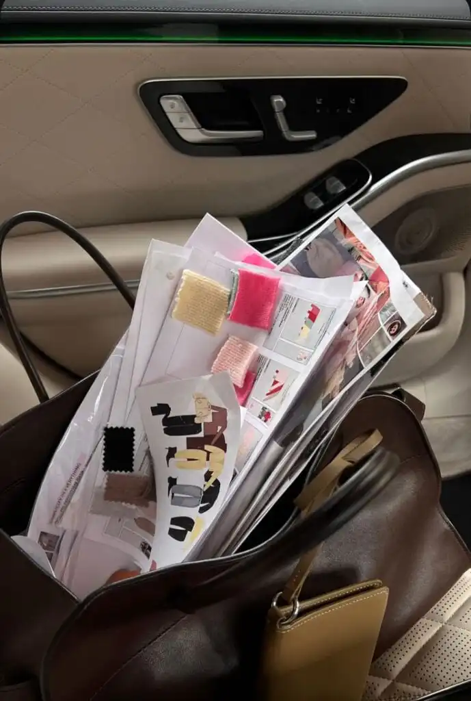 _ 2 Bag with fabric swatches and fashion sketches placed on a car seat, hinting at a designer's work in progress. | Sky Rye Design Bag with fabric swatches and fashion sketches placed on a car seat, hinting at a designer's work in progress.