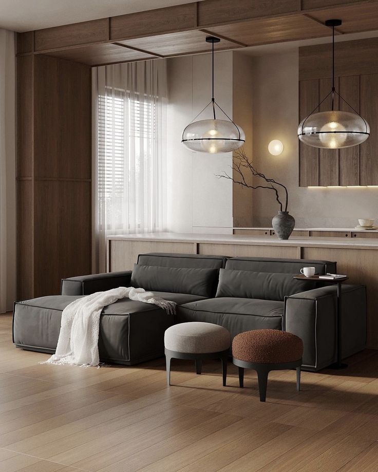 Screenshot Modern living room with a dark gray sectional sofa, cozy throw, stylish pendant lights, and wooden accents. Minimalist and inviting decor. | Sky Rye Design Modern living room with a dark gray sectional sofa, cozy throw, stylish pendant lights, and wooden accents. Minimalist and inviting decor.