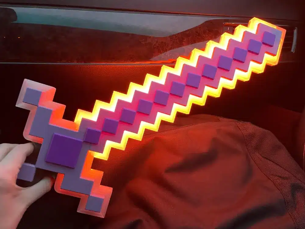 2025-06-08_fc917a4937d9d8 Pixelated sword glowing with bright purple and orange colors, held by a hand against a dark background. Perfect for gaming enthusiasts. | Sky Rye Design Pixelated sword glowing with bright purple and orange colors, held by a hand against a dark background. Perfect for gaming enthusiasts.