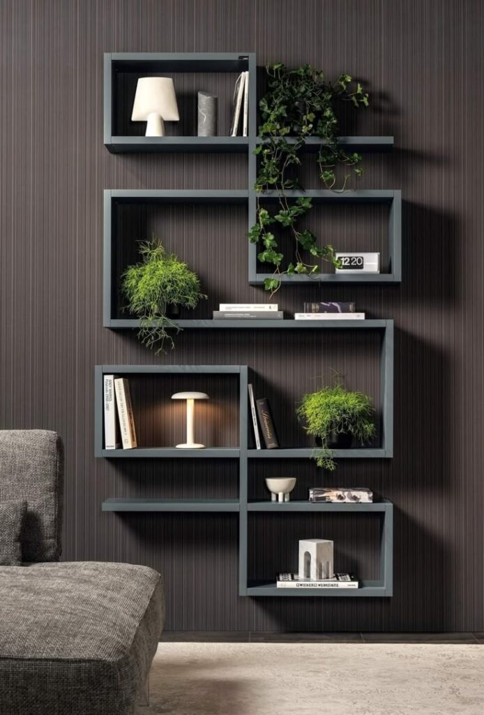 _ - 2025-12-01T202030257 Modern wall-mounted shelving with decorative plants, books, and lamps against a dark striped background, enhancing interior design. | Sky Rye Design Modern wall-mounted shelving with decorative plants, books, and lamps against a dark striped background, enhancing interior design.
