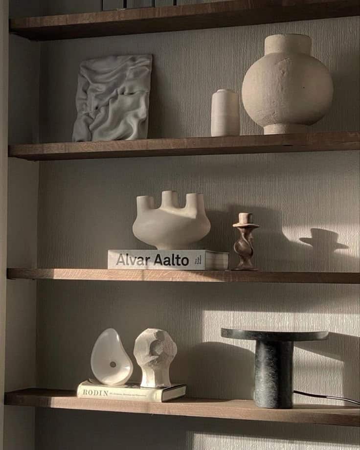 _ - 2025-12-01T203331808 Minimalist wooden shelves with abstract sculptures, books, and ceramic vases in soft lighting, creating an artistic display. | Sky Rye Design Minimalist wooden shelves with abstract sculptures, books, and ceramic vases in soft lighting, creating an artistic display.