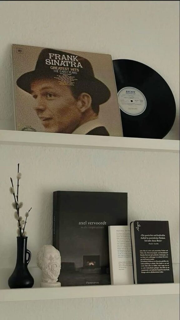 _ - 2025-12-01T211311249 Vinyl record of Frank Sinatra's greatest hits and books on a minimalist shelf with a decorative vase and bust. Classic home decor. | Sky Rye Design Vinyl record of Frank Sinatra's greatest hits and books on a minimalist shelf with a decorative vase and bust. Classic home decor.