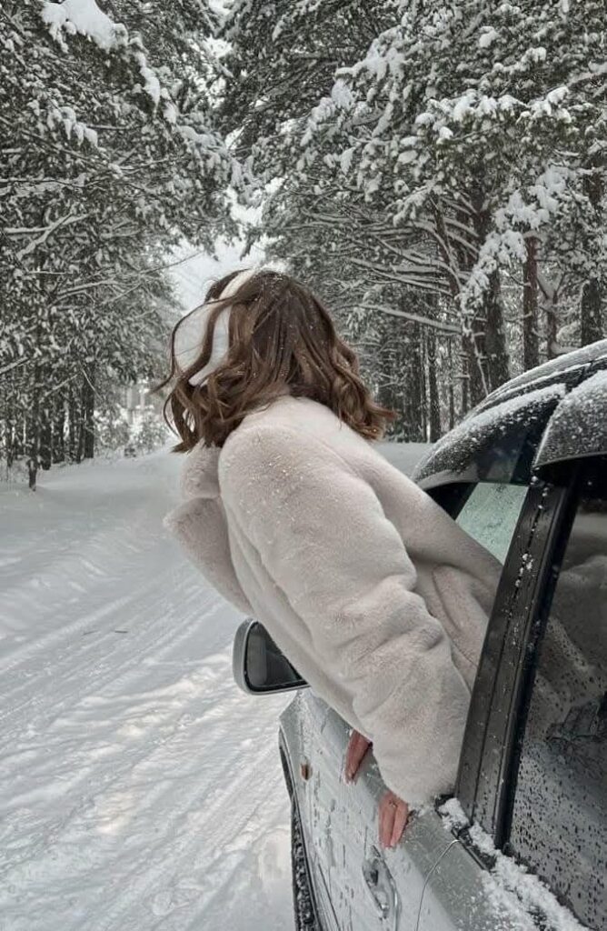 _ - 2025-12-04T130716740 Woman in a white coat leans out of a car window on a snowy forest road, enjoying winter scenery. | Sky Rye Design Woman in a white coat leans out of a car window on a snowy forest road, enjoying winter scenery.