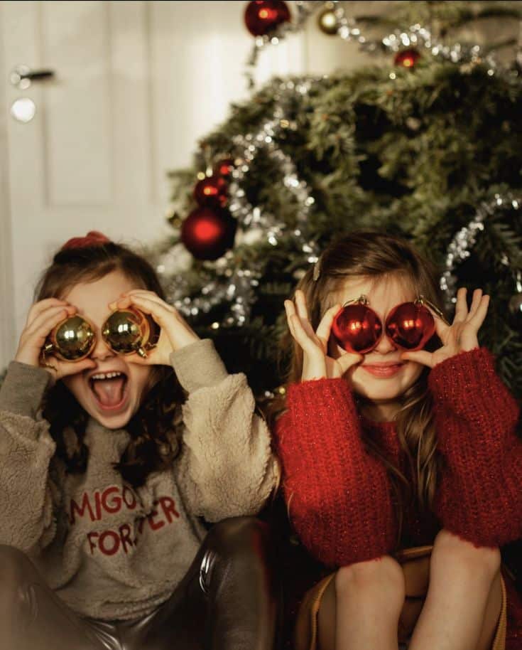 _ - 2025-12-04T131106749 Children playing with Christmas ornaments in front of a decorated tree, embodying festive joy and holiday cheer. | Sky Rye Design Children playing with Christmas ornaments in front of a decorated tree, embodying festive joy and holiday cheer.