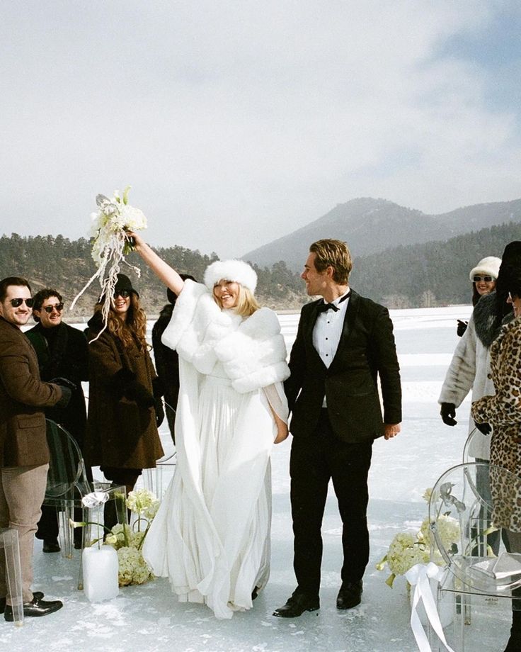 _ - 2025-12-04T131307496 Bride and groom joyfully celebrate their winter wedding on a frozen lake, surrounded by friends and snow-capped mountains. | Sky Rye Design Bride and groom joyfully celebrate their winter wedding on a frozen lake, surrounded by friends and snow-capped mountains.
