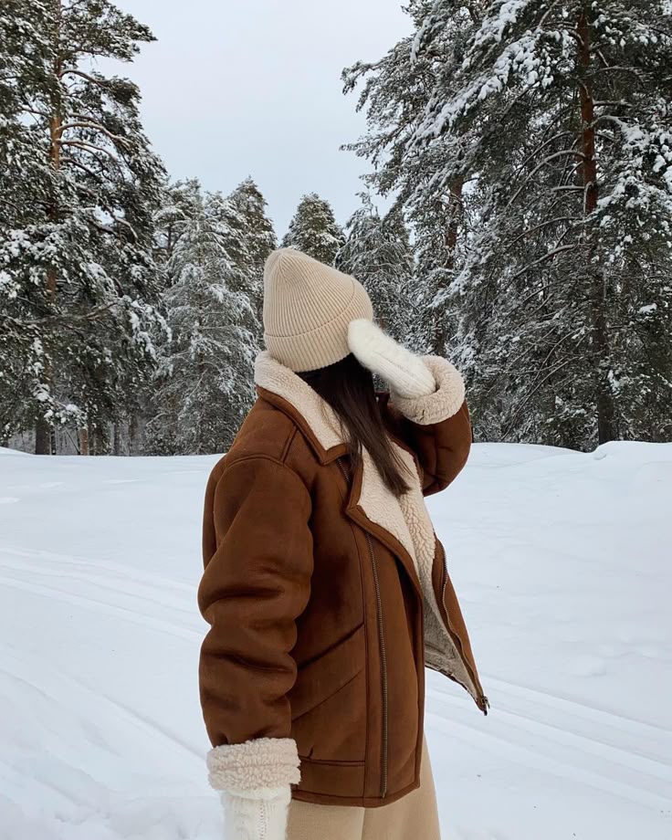 _ - 2025-12-04T132302202 Woman in brown shearling jacket and beige beanie enjoying snowy forest scenery. Winter fashion in picturesque woodland setting. | Sky Rye Design Woman in brown shearling jacket and beige beanie enjoying snowy forest scenery. Winter fashion in picturesque woodland setting.