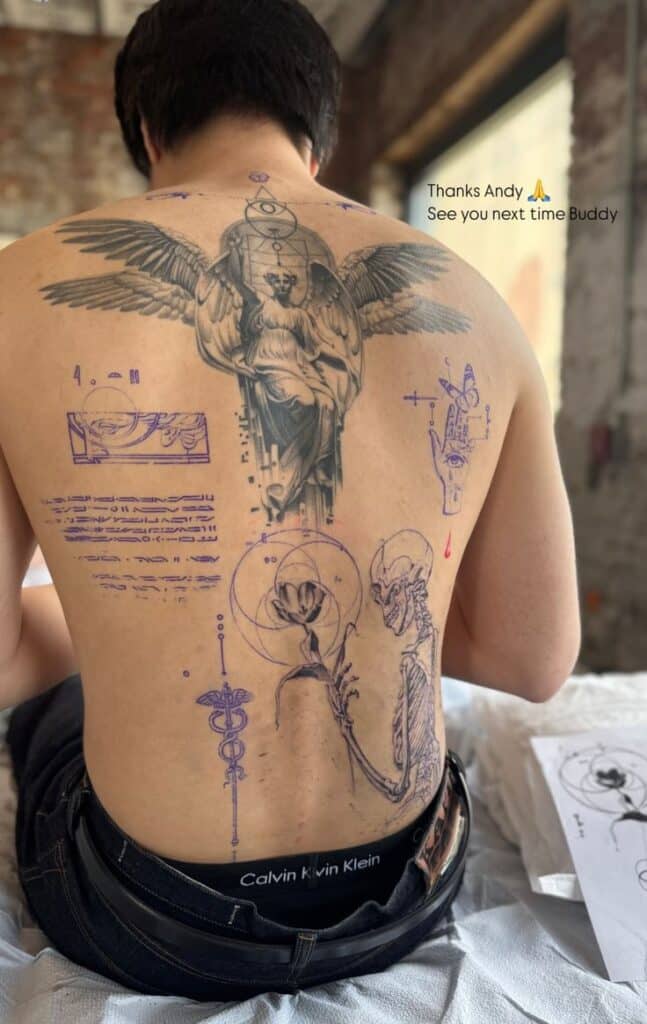 Man with intricate back tattoos featuring angels, geometric shapes, and symbols. Text: Thanks Andy 🙏 See you next time Buddy.
