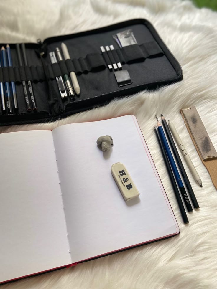 _ - 2025-12-10T114842003 Open sketchbook with drawing pencils and erasers on a fluffy surface, ready for creative projects. Ideal for artists and designers. | Sky Rye Design Open sketchbook with drawing pencils and erasers on a fluffy surface, ready for creative projects. Ideal for artists and designers.