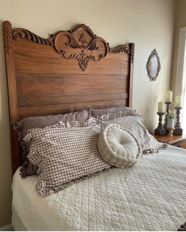 _ - 2025-12-10T134619054 Elegant wooden headboard with intricate carvings, cozy checkered pillows, and a quilted bedspread in a warmly lit bedroom. | Sky Rye Design Elegant wooden headboard with intricate carvings, cozy checkered pillows, and a quilted bedspread in a warmly lit bedroom.