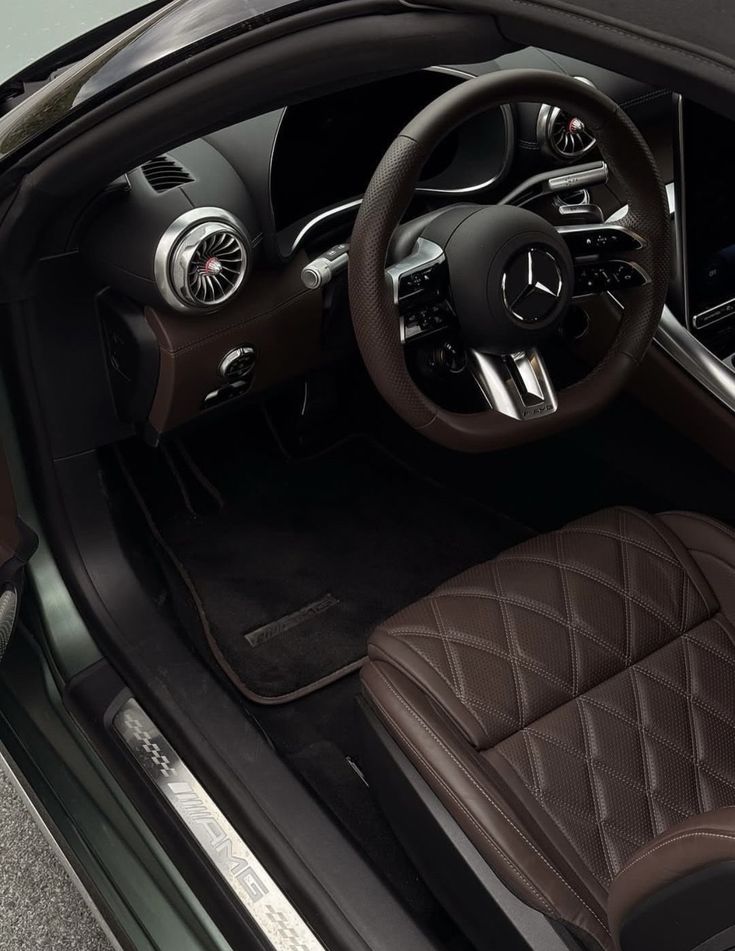 Luxury car interior featuring a sleek steering wheel and elegant diamond-stitched leather seats, showcasing premium automotive design.