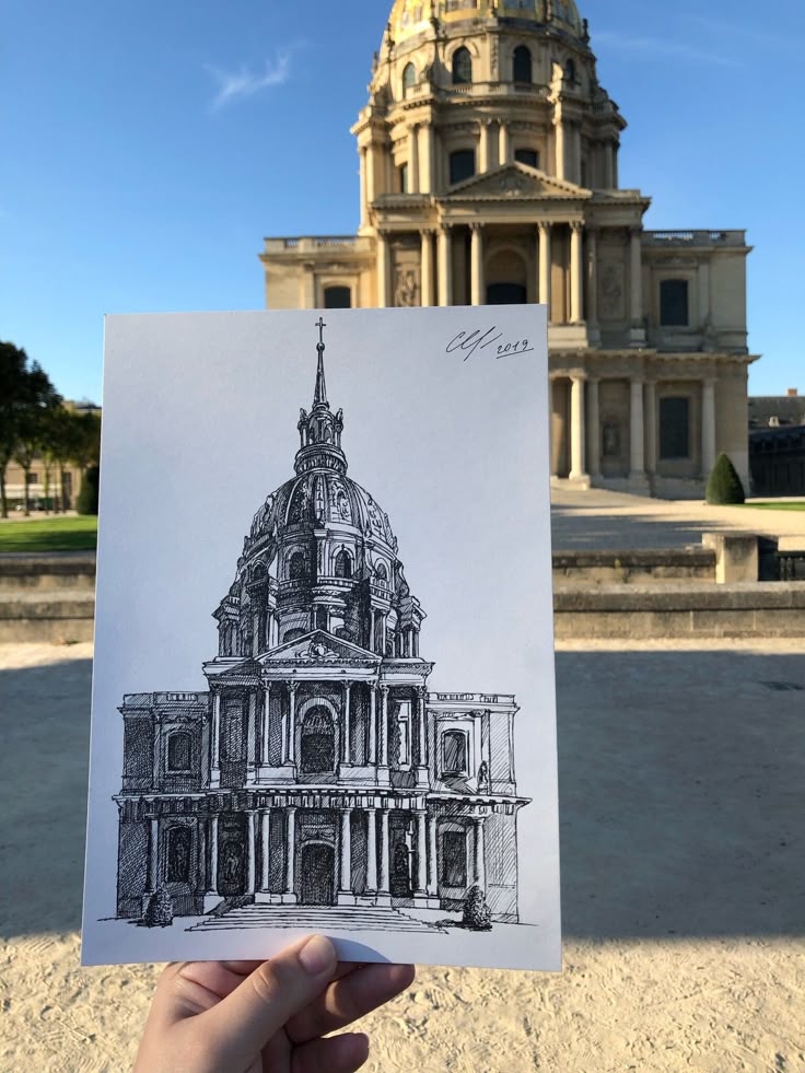 _ - 2025-12-12T013235690 A hand holds a detailed architectural sketch, aligned with the real building in the background, showcasing artistic interpretation. | Sky Rye Design A hand holds a detailed architectural sketch, aligned with the real building in the background, showcasing artistic interpretation. Architecture Sketching