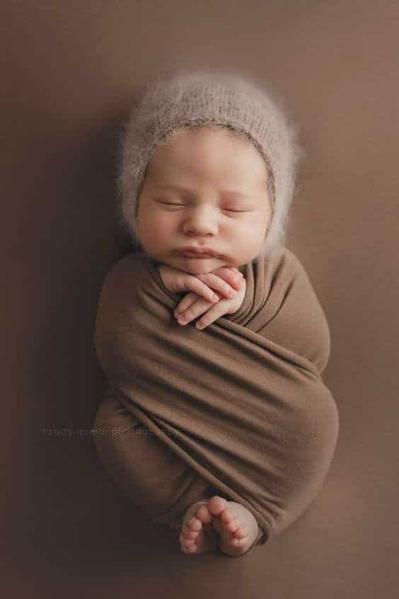 _ - 2025-12-12T124428270 Newborn baby peacefully sleeping, wrapped in a cozy brown blanket with a knitted hat, against a matching background. | Sky Rye Design Newborn baby peacefully sleeping, wrapped in a cozy brown blanket with a knitted hat, against a matching background.
