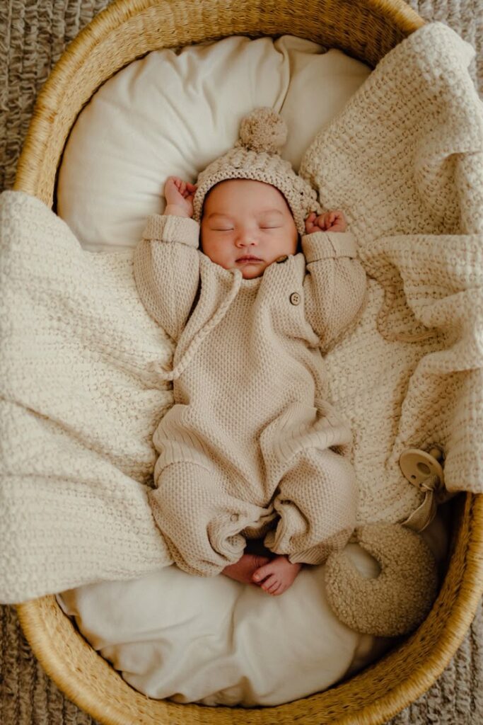 _ - 2025-12-12T131423071 Sleeping baby in cozy beige knit outfit, cuddled in a soft basket. Peaceful newborn portrait for nursery decor or parenting blog. | Sky Rye Design Sleeping baby in cozy beige knit outfit, cuddled in a soft basket. Peaceful newborn portrait for nursery decor or parenting blog.