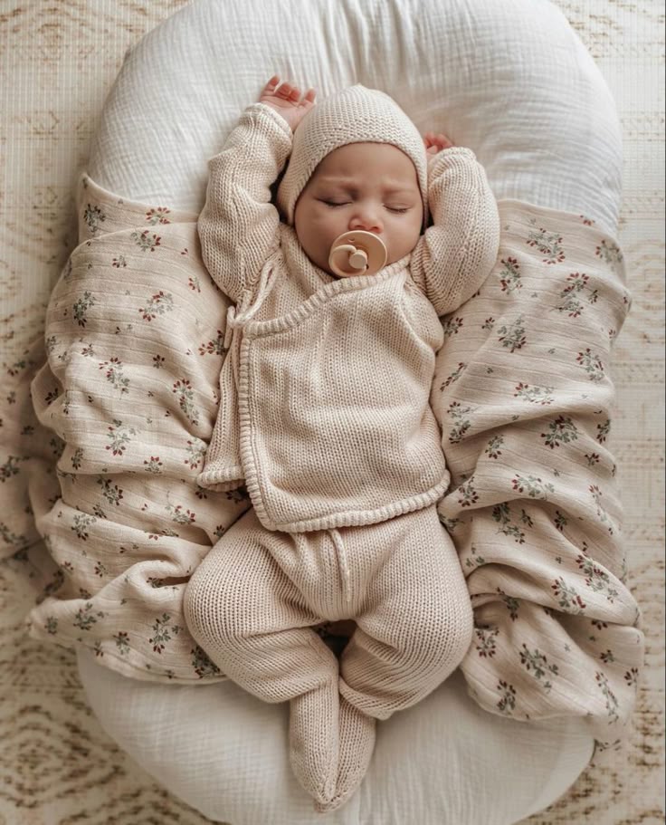 _ - 2025-12-12T131725934 Cute sleeping baby in a cozy beige knit outfit and hat, nestled on a floral blanket with a pacifier. Peaceful nap time. | Sky Rye Design Cute sleeping baby in a cozy beige knit outfit and hat, nestled on a floral blanket with a pacifier. Peaceful nap time.
