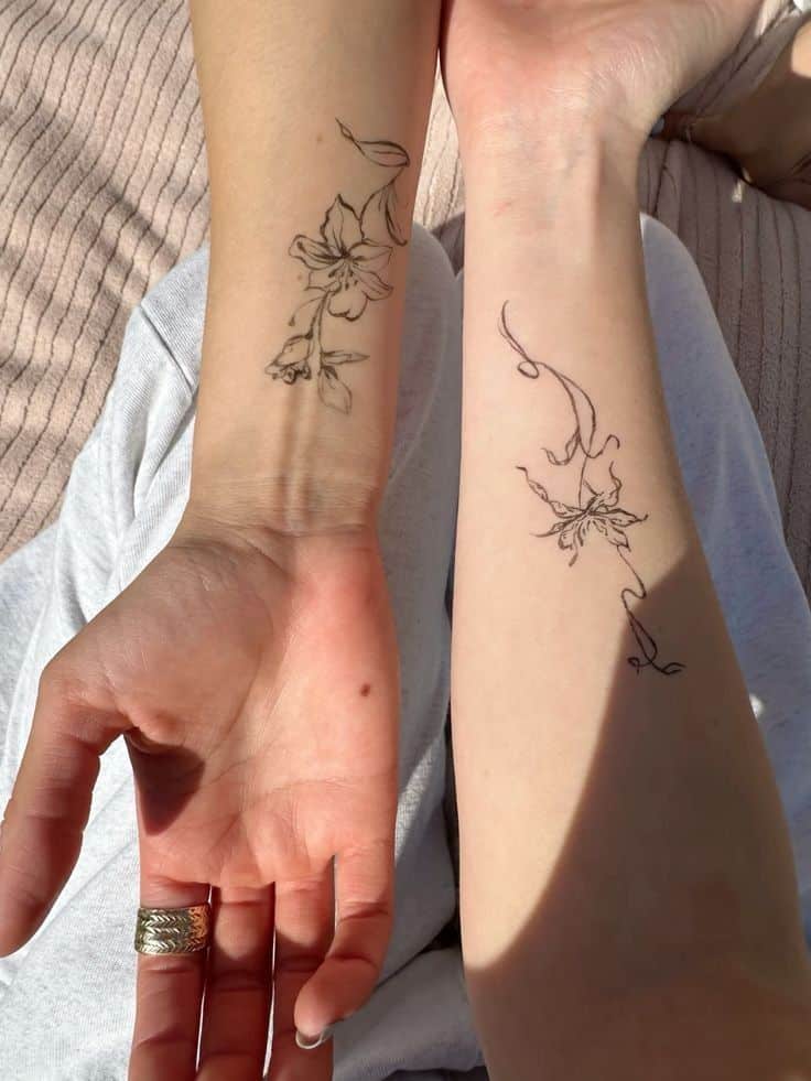 _ - 2025-12-12T144402098 Two arms with delicate floral line tattoos, one featuring blossoms, captured in sunlight for a minimalist aesthetic. | Sky Rye Design Two arms with delicate floral line tattoos, one featuring blossoms, captured in sunlight for a minimalist aesthetic.