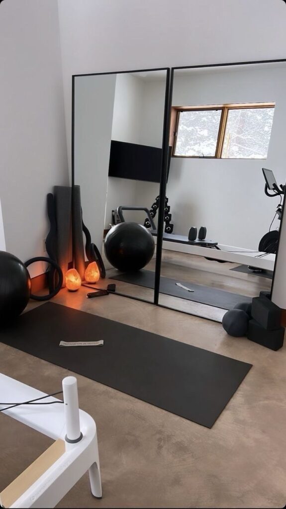 _ - 2025-12-16T231834230 Modern home gym with yoga mats, exercise balls, weights, and mirrors, creating a sleek workout space with natural light from a window. | Sky Rye Design Modern home gym with yoga mats, exercise balls, weights, and mirrors, creating a sleek workout space with natural light from a window.