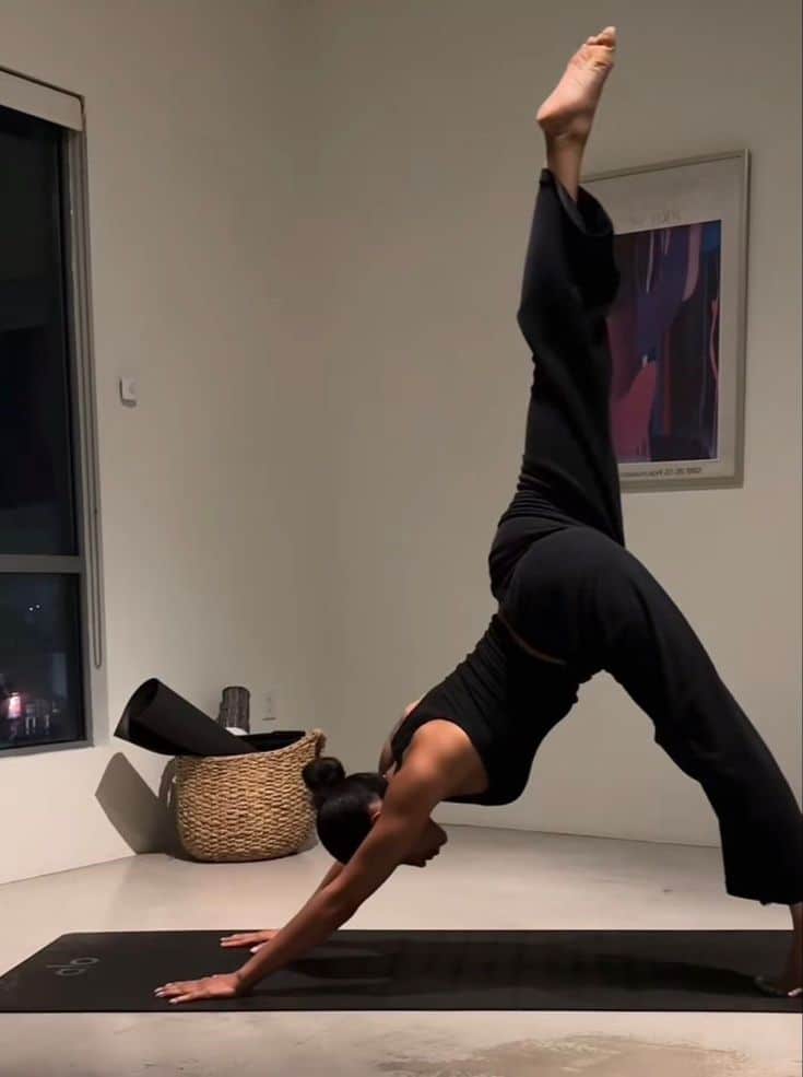 _ - 2025-12-16T232259599 Person practicing yoga at home, performing a one-legged downward dog pose on a mat, in a minimalist room. | Sky Rye Design Person practicing yoga at home, performing a one-legged downward dog pose on a mat, in a minimalist room.