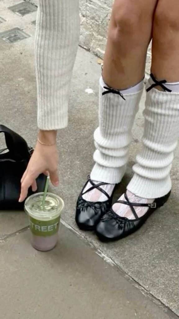 _ - 2025-12-28T125651282 Person with white socks and black ballet flats reaching for a green smoothie on the pavement. Casual street style fashion. | Sky Rye Design Person with white socks and black ballet flats reaching for a green smoothie on the pavement. Casual street style fashion. Ballerina Flats