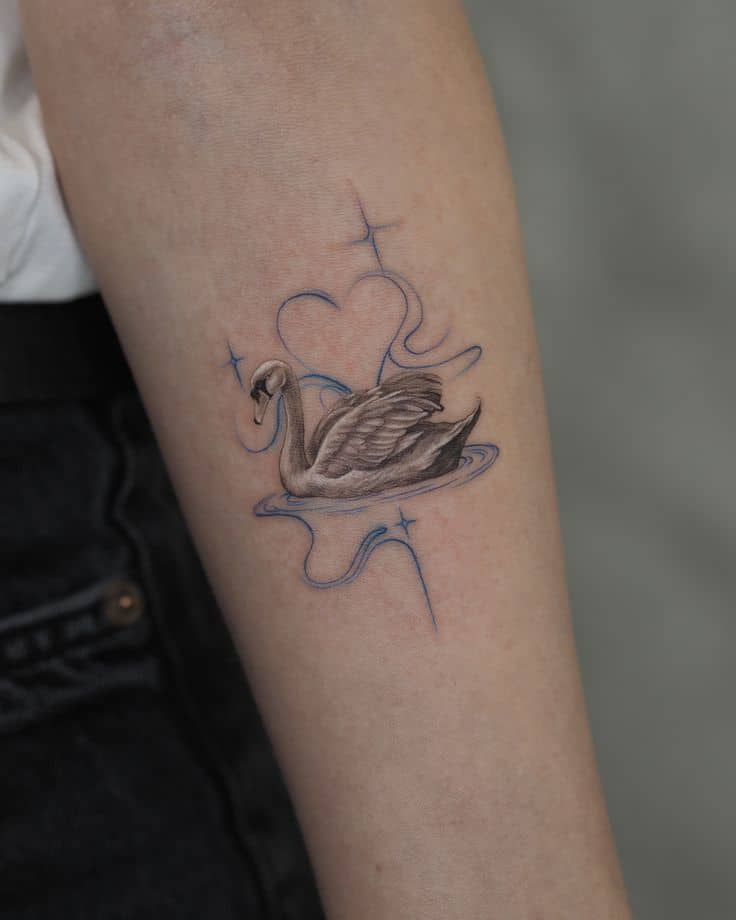 OLYMPUS DIGITAL CAMERA Delicate swan tattoo with heart and star accents on arm, showcasing intricate design and graceful art. | Sky Rye Design Delicate swan tattoo with heart and star accents on arm, showcasing intricate design and graceful art.