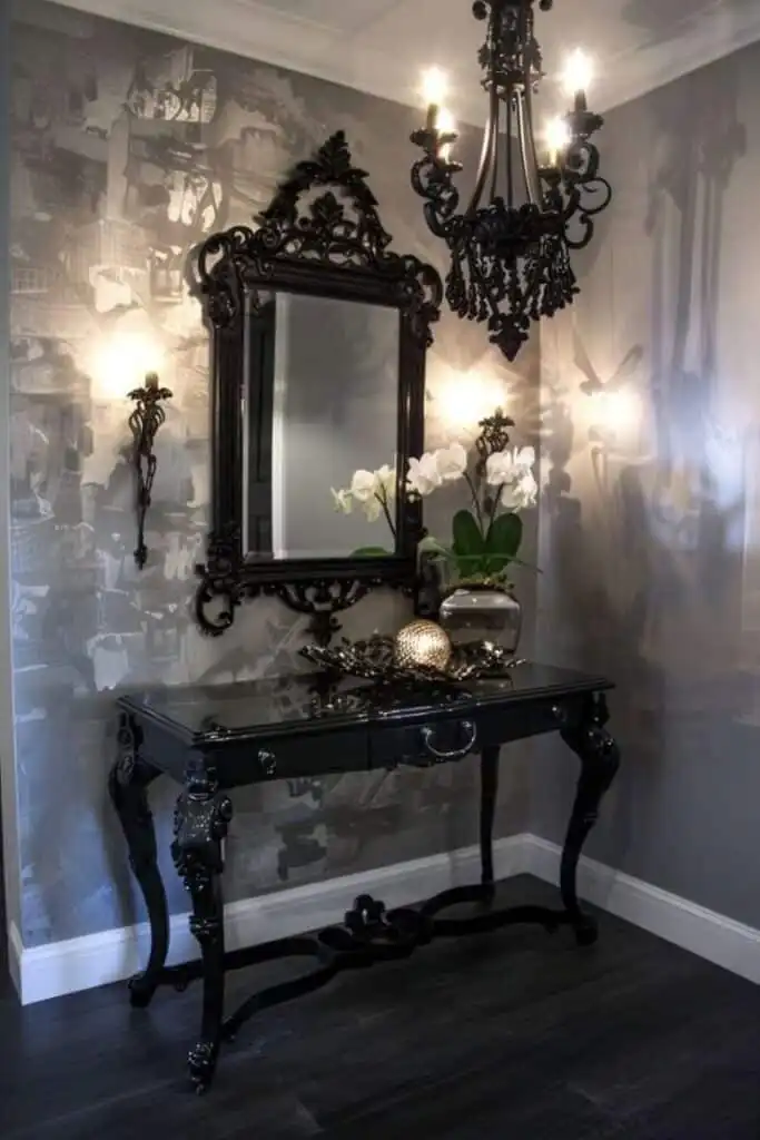 Elegant black hallway table with ornate mirror, chandelier, and white orchids, creating a sophisticated and stylish entryway decor.